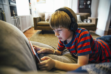 Caucasian boy using digital tablet on sofa - BLEF05742