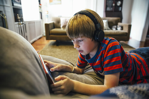 Kaukasischer Junge mit digitalem Tablet auf dem Sofa - BLEF05742