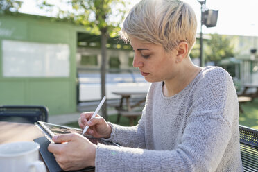 Junge Frau benutzt digitales Tablet im Freien - FBAF00609