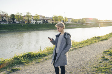 Junge Frau benutzt Mobiltelefon im Freien - FBAF00618