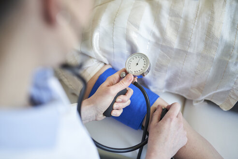 Close-up of doctor taking blood pressure of patient in medical practice - PNEF01501