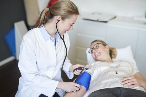 Female doctor taking blood pressure of patient in medical practice - PNEF01503