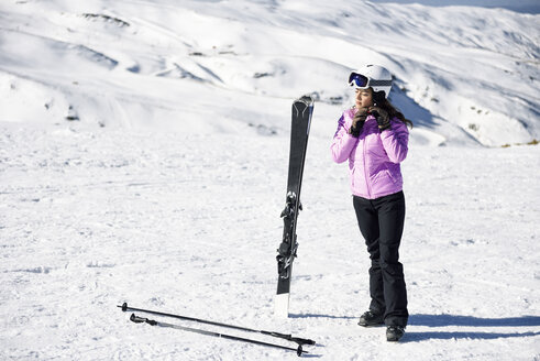 Frau in Skikleidung bei der Vorbereitung zum Skifahren in der Sierra Nevada, Andalusien, Spanien - JSMF01095