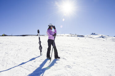 Frau in Skikleidung bei der Vorbereitung zum Skifahren in der Sierra Nevada, Andalusien, Spanien - JSMF01098