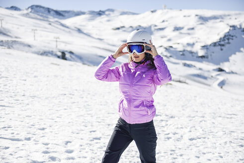 Frau in Skikleidung bei der Vorbereitung zum Skifahren in der Sierra Nevada, Andalusien, Spanien - JSMF01104