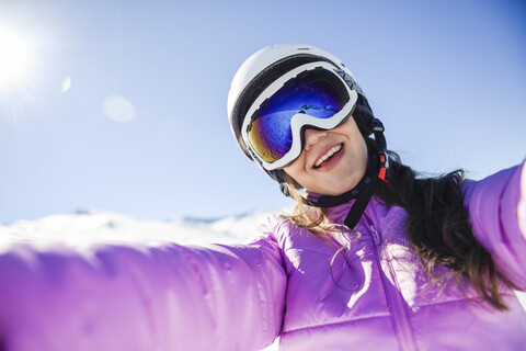 Selfie einer glücklichen jungen Frau in Skikleidung, lizenzfreies Stockfoto