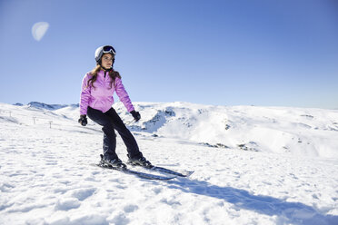 Frau beim Skifahren unter blauem Himmel, Sierra Nevada, Andalusien, Spanien - JSMF01119