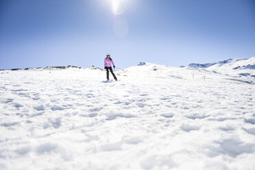 Frau beim Skifahren unter blauem Himmel, Sierra Nevada, Andalusien, Spanien - JSMF01121