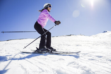 Woman skiing under blue sky, Sierra Nevada, Andalusia, Spain - JSMF01123