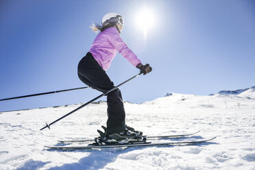 Frau beim Skifahren unter blauem Himmel, Sierra Nevada, Andalusien, Spanien - JSMF01124
