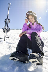 Frau macht eine Pause nach dem Skifahren auf dem verschneiten Boden in der Sierra Nevada, Andalusien, Spanien - JSMF01131