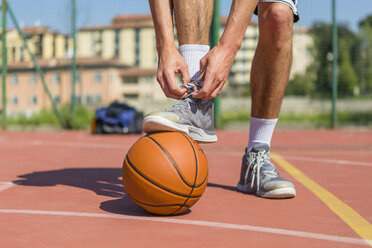 Junger Basketballspieler beim Schuhe binden - MGIF00485