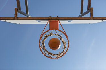 Basketball and hoop, blue sky, upward view - MGIF00492