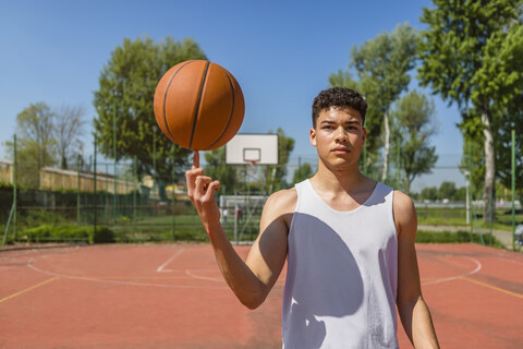 Junger Mann spielt mit Basketball, lizenzfreies Stockfoto
