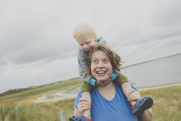 Porträt einer glücklichen Mutter, die ihre kleine Tochter auf den Schultern trägt, Sylt, Deutschland - IHF00051