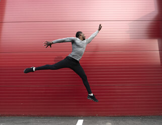 Athlete jumping in front of a red wall - AHSF00410
