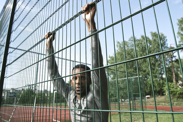 Portrait of sportsman behind fence - AHSF00421