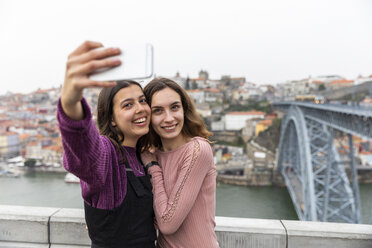 Porträt von zwei besten Freunden, die ein Selfie mit ihrem Smartphone machen, Porto, Portugal - WPEF01566