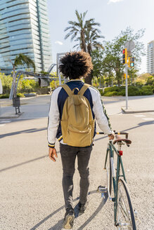 Rückansicht eines lässigen Geschäftsmannes mit Fahrrad in der Stadt unterwegs, Barcelona, Spanien - AFVF03042