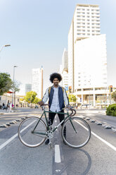 Porträt eines lächelnden lässigen Geschäftsmannes mit Fahrrad in der Stadt, Barcelona, Spanien - AFVF03045