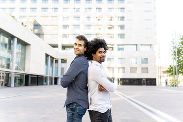 Porträt von zwei selbstbewussten Geschäftsleuten, die Rücken an Rücken in der Stadt stehen, Barcelona, Spanien - AFVF03088