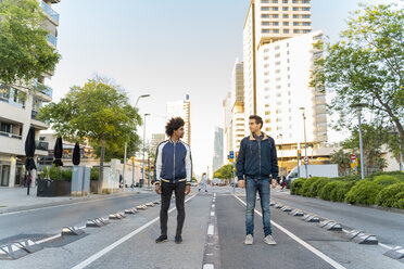 Two men standing on the street in the city facing each other, Barcelona, Spain - AFVF03154