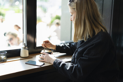 Junge Frau entspannt sich in einem Kaffeehaus, lizenzfreies Stockfoto