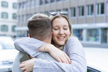 Portrait of happy young woman hugging her boyfriend - FBAF00641