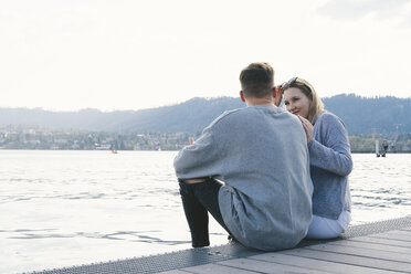Junges Paar sitzt auf einem Steg am Zürichsee, Zürich, Schweiz - FBAF00648