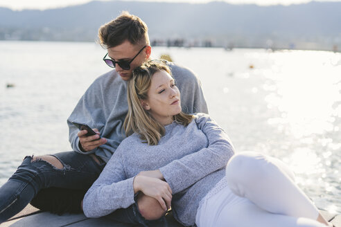 Junges Paar entspannt sich auf einem Steg am Zürichsee, Zürich, Schweiz - FBAF00655