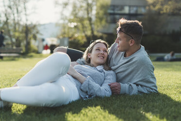 Young couple relaxing on a meadow at sunlight - FBAF00659