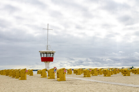 Blick auf den Strand mit Strandkörben mit Kapuze und Wärterturm, Lübeck Travemünde, Deutschland, lizenzfreies Stockfoto