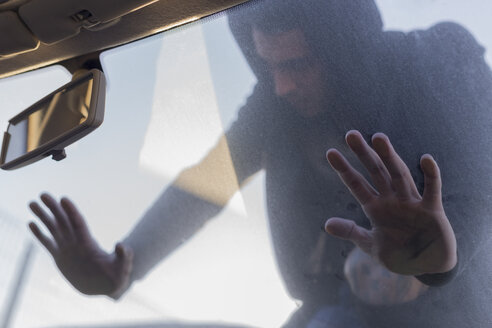 Junger Mann lehnt an der Windschutzscheibe eines alten Autos auf dem Schrottplatz - JPTF00078