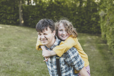 A smiling girl riding on her big brother's back - IHF00068