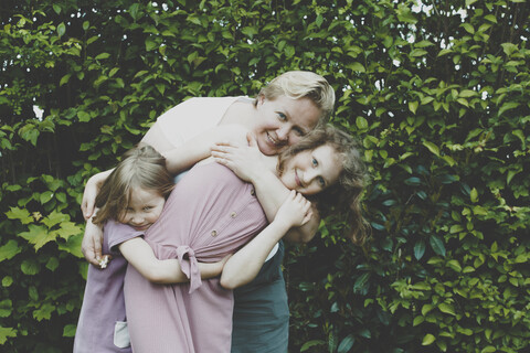 Eine Mutter, die ihre Töchter umarmt, lizenzfreies Stockfoto