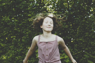A girl jumping with her eyes closed - IHF00071