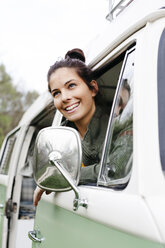 Young woman sitting in camperm looking out of window - HMEF00458