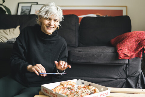 Frau isst Pizza zu Hause, lizenzfreies Stockfoto