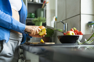 Woman chopping fruits in her kitchen, close up - FBAF00672