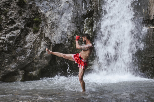 Junger Mann beim Boxtraining an einem Wasserfall - LJF00075