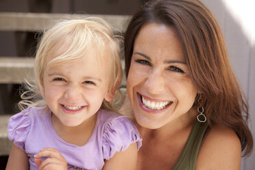 Caucasian mother and daughter smiling on steps - BLEF05746