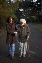 Woman walking with mother on paved path - BLEF05766