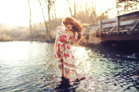 Hispanic woman standing in rural lake stock photo