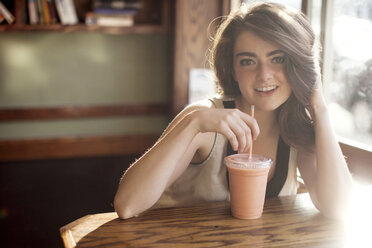 Caucasian teenage girl drinking smoothie in cafe - BLEF05805