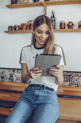 Porträt einer jungen Frau, die lächelnd ein Tablet in einem Café benutzt - ACPF00521