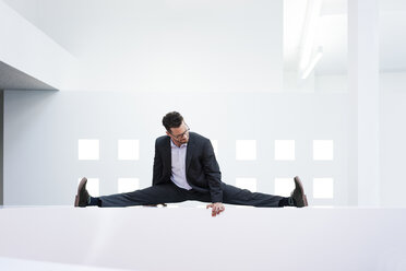 Businessman leaning on reception desk in office - MOEF02185