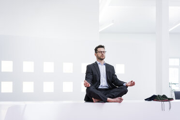 Geschäftsmann macht Yoga im Büro - MOEF02197