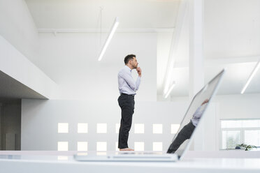 Thoughtful businessman at laptop in office - MOEF02209