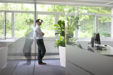 Geschäftsmann mit VR-Brille im Büro - MOEF02224