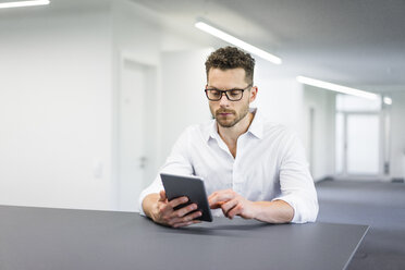 Businessman using tablet in office - MOEF02246